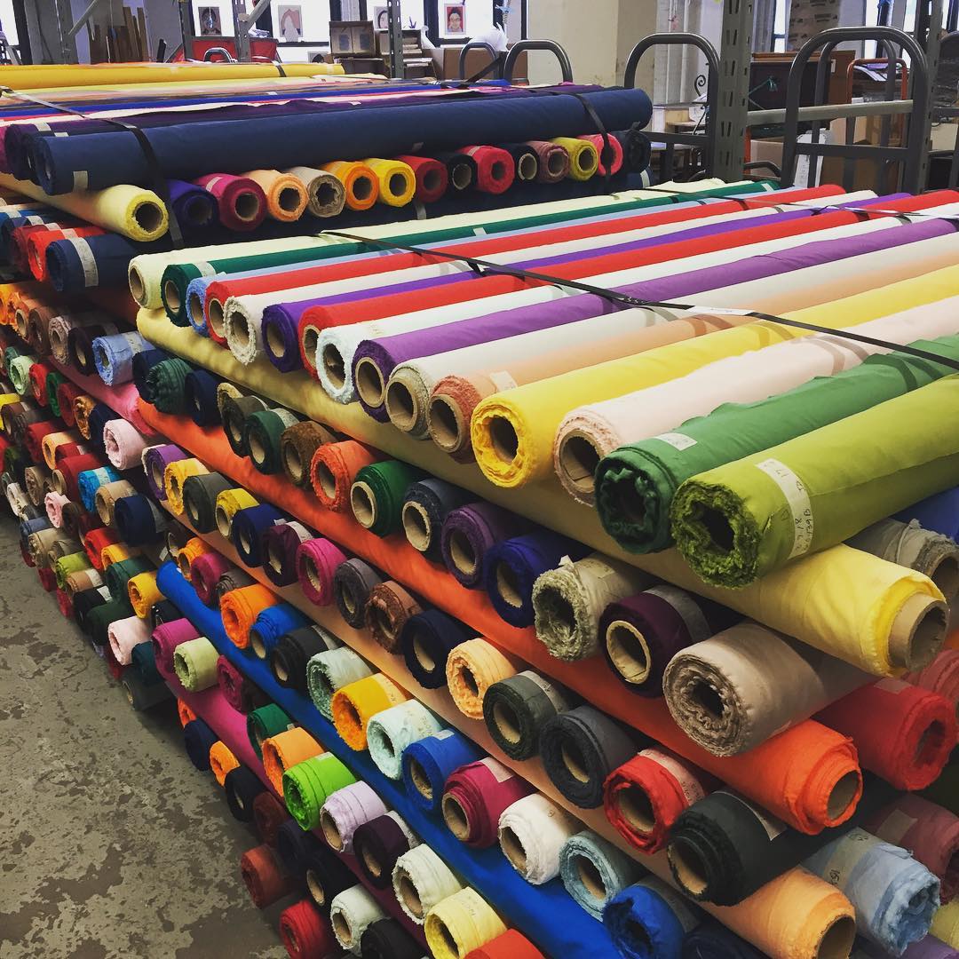 Rolls of Many Different Colored Fabrics in a Warehouse. Photo by Instagram user @materialsforthearts