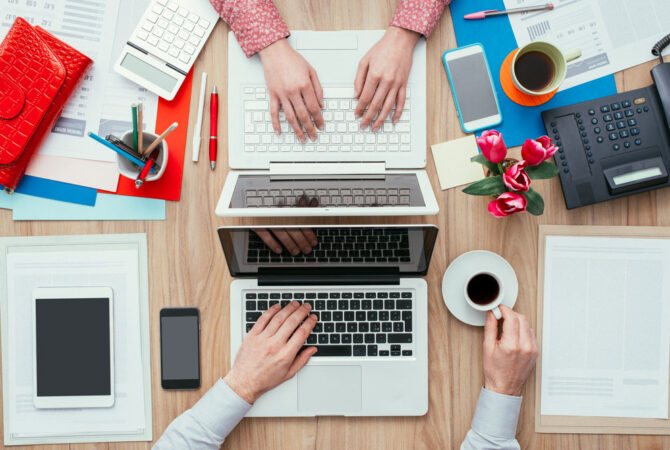 Two people working at the same desk