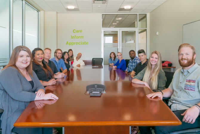 Employees at Extra Space Storage gathered around conference room table