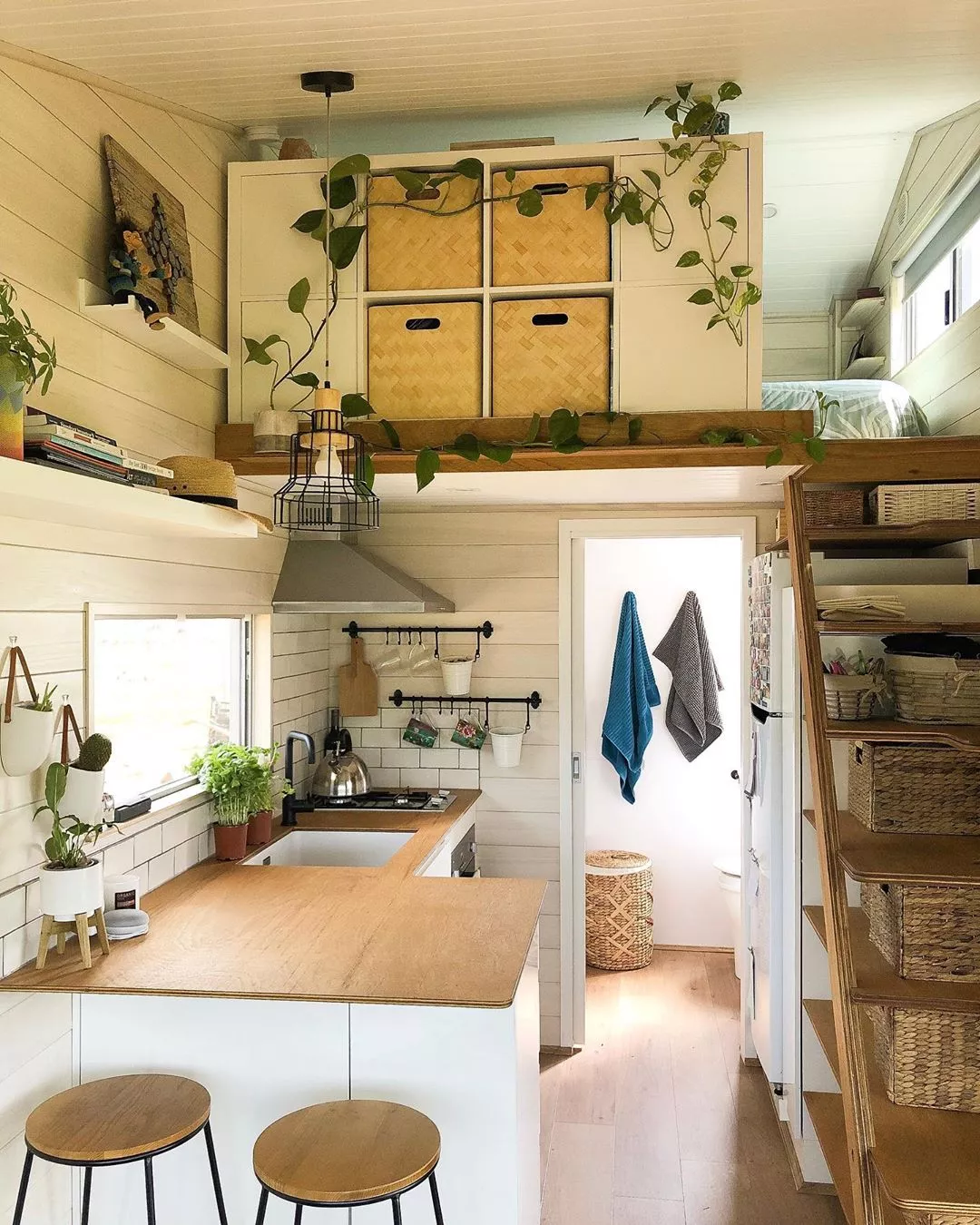 Rustic tiny house has a spacious interior and a balcony up top