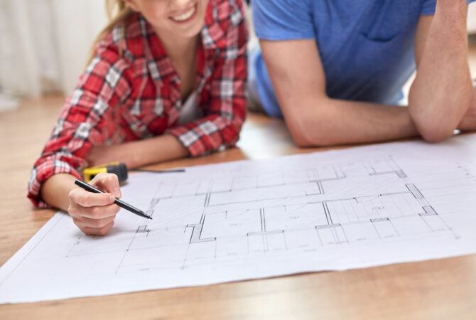 young couple looking a home blueprints