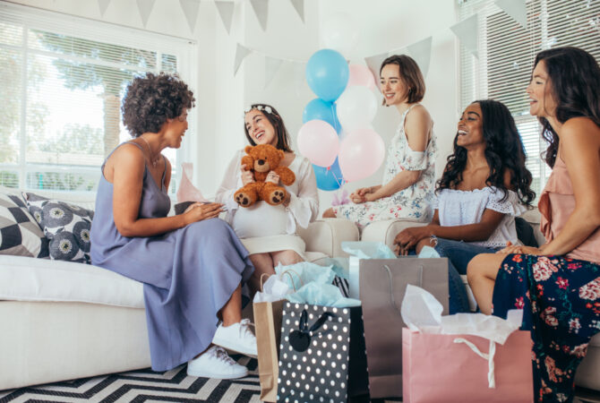 Friends gather around a pregnant woman during her baby shower.