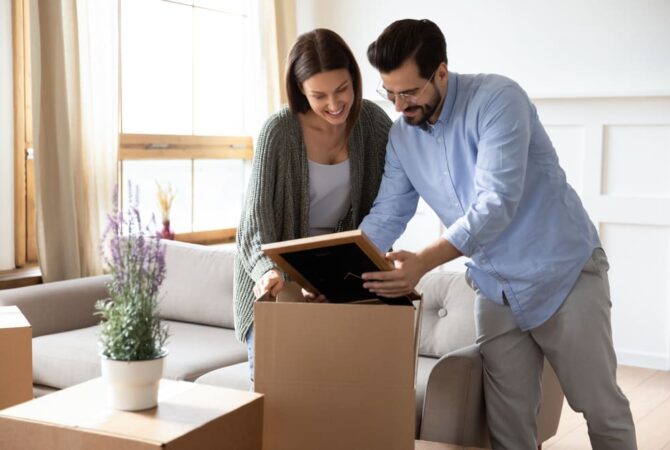 A couple packing their artwork for moving.