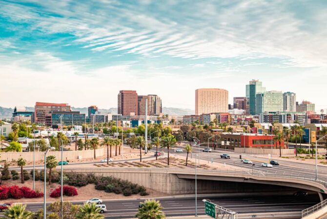 A skyline photo of Phoenix featuring tall buildings and roadways