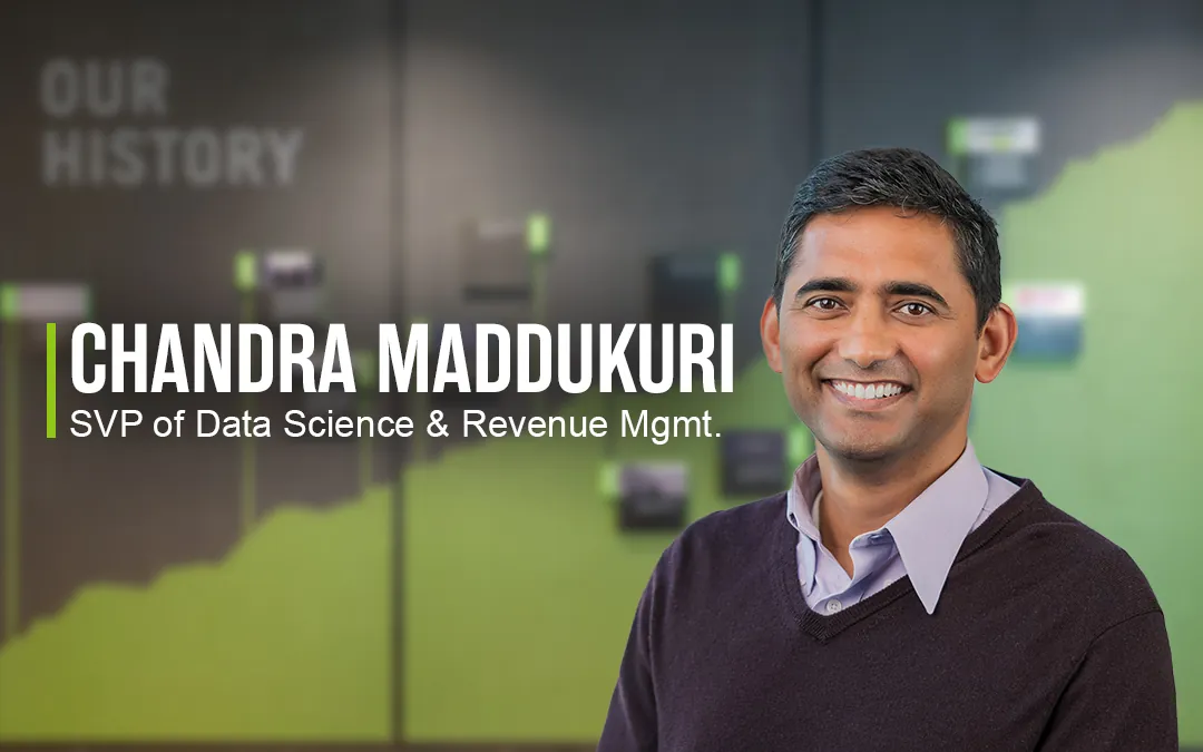 Chandra Maddukuri, a man with short dark hair wearing a sweater over a collared shirt while smiling beside his name and title as SVP of Data Science and Revenue Management at Extra Space Storage